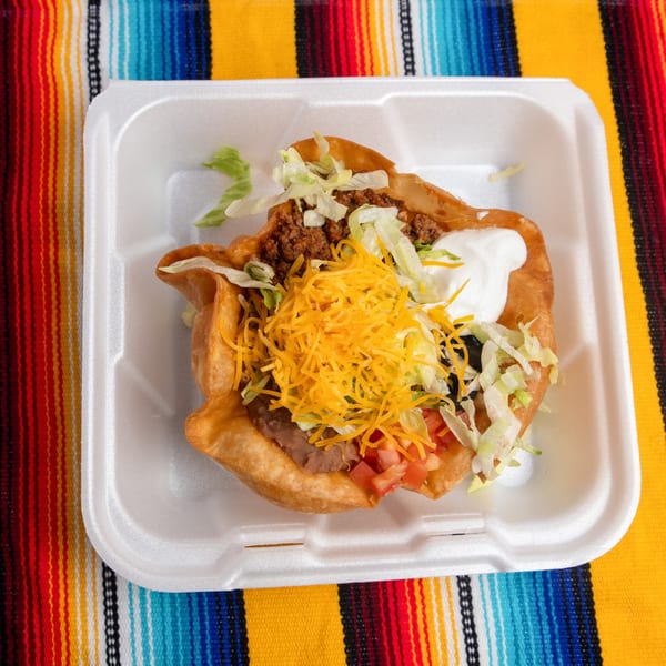 A Pepe's Mexican Café taco salad in a fried tortilla bowl, with ground beef, cheese, and sour cream.