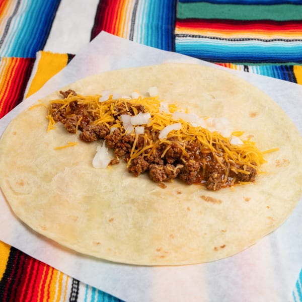 A Pepe's Mexican Café tortilla filled with seasoned ground beef, shredded cheese, and diced onions.
